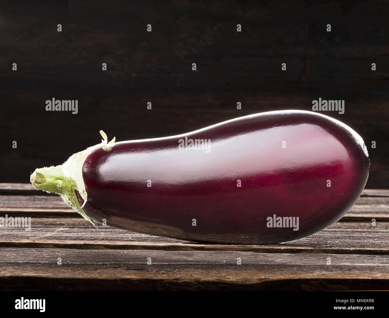 Eine aubergine auf einem hölzernen Hintergrund Stockfoto