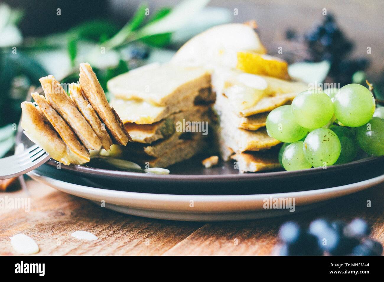 Gestapelte Pfannkuchen mit Trauben und Mandelflocken Stockfoto