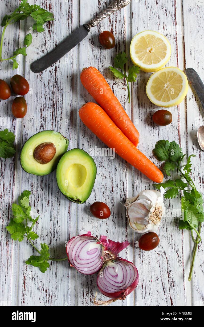 Eine Anordnung mit Avocado, Karotten, Zitronen, Zwiebeln und Tomaten Stockfoto