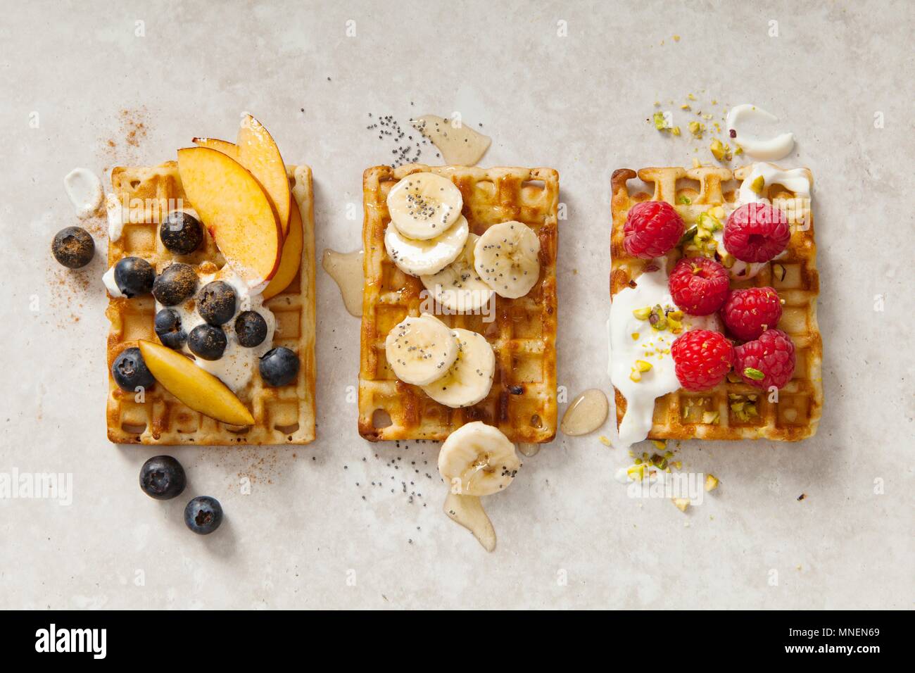 Belgische Waffeln mit drei verschiedenen Toppings (von oben gesehen) Stockfoto