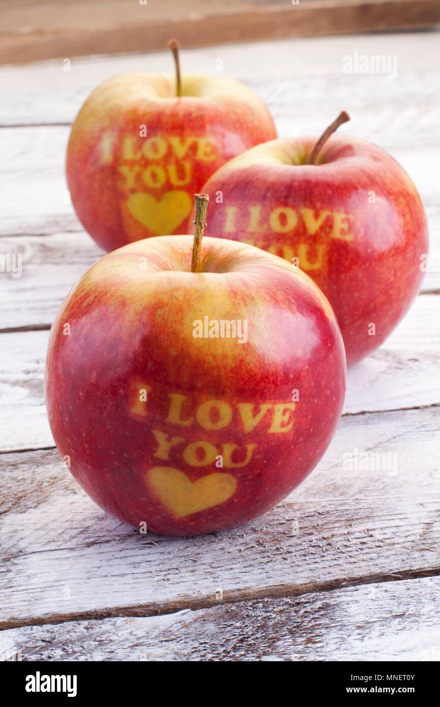 Drei rote Äpfel mit Herzen und die Worte "Ich liebe Dich" geschnitzt Stockfoto