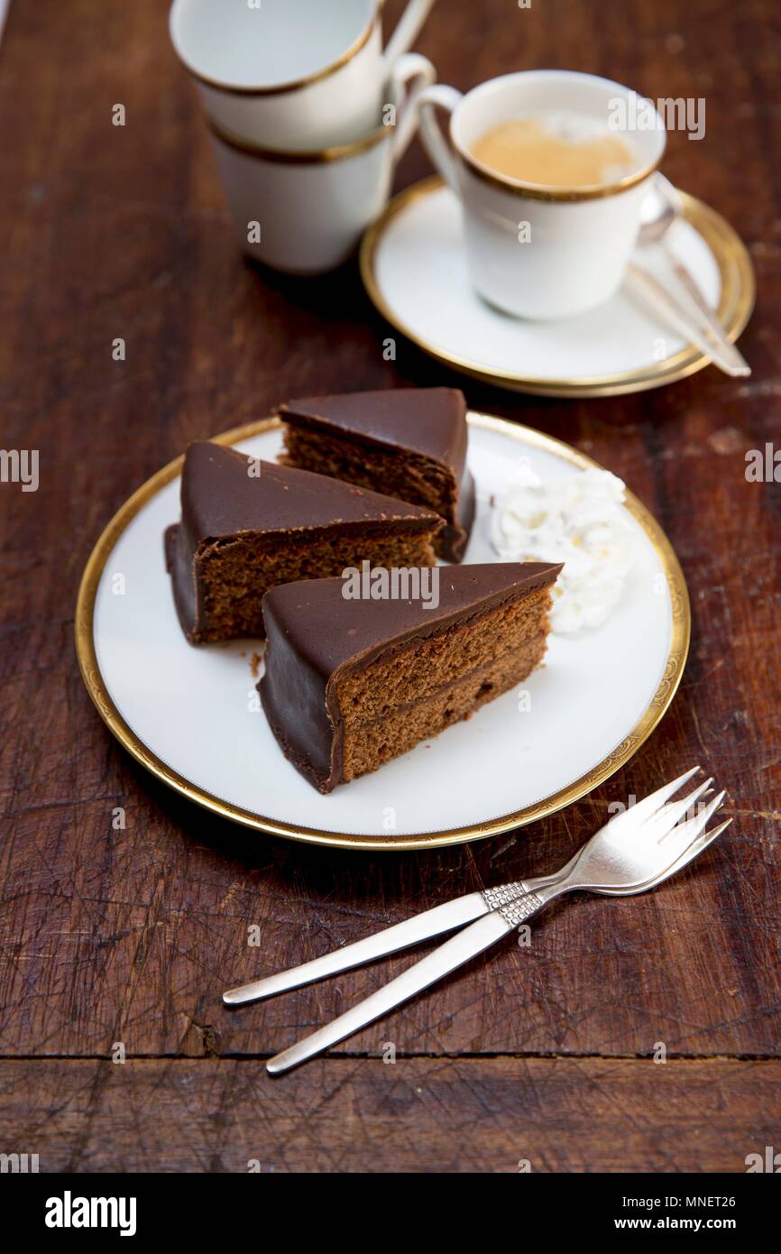 Sachertorte (Rich) Österreichische Schokolade Kuchen mit Schlagsahne und eine Tasse Kaffee Stockfoto