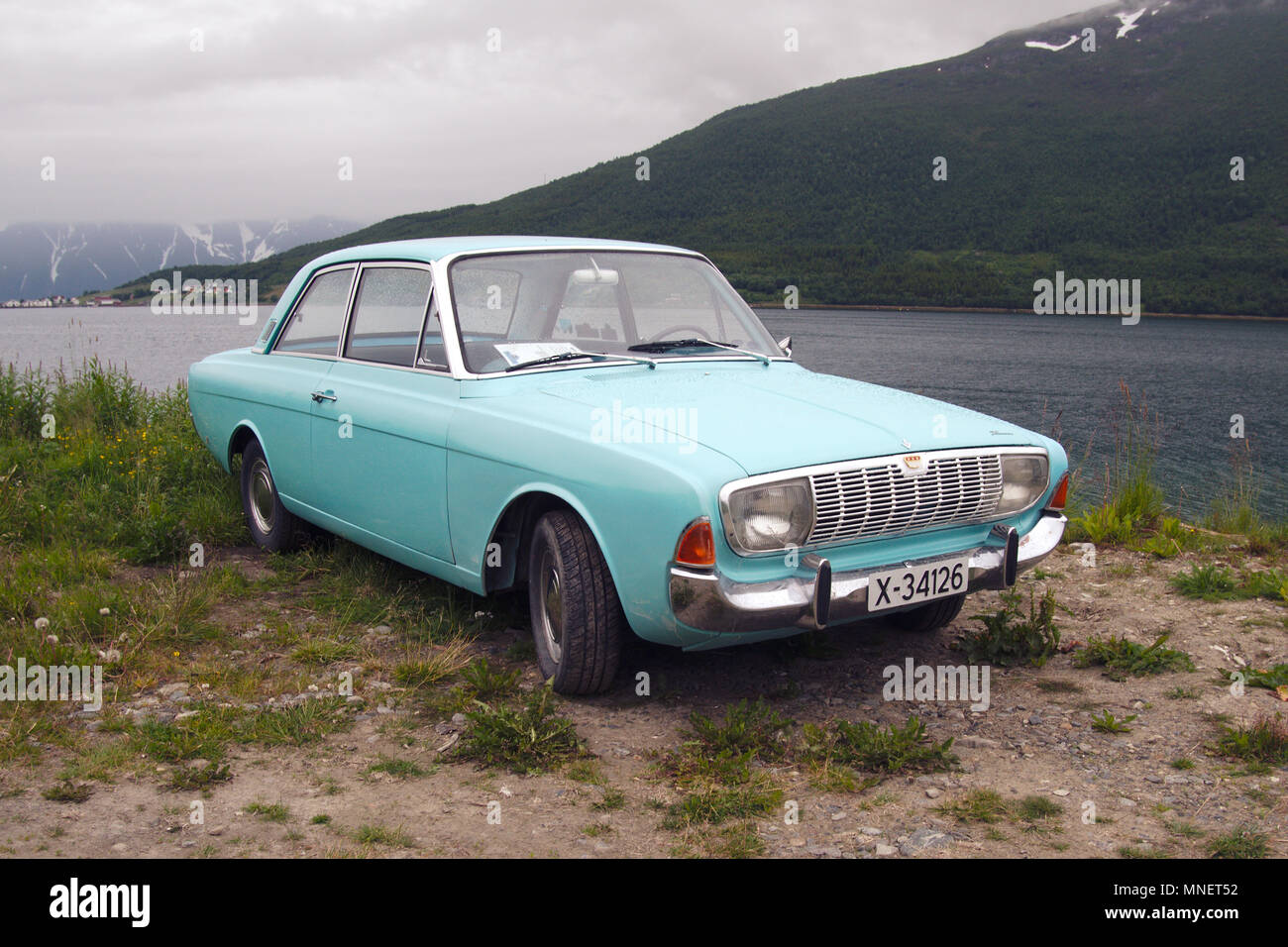 A 1964 Ford Taunus in neuwertigem Zustand steht neben einem Fjord in Norwegen. Stockfoto