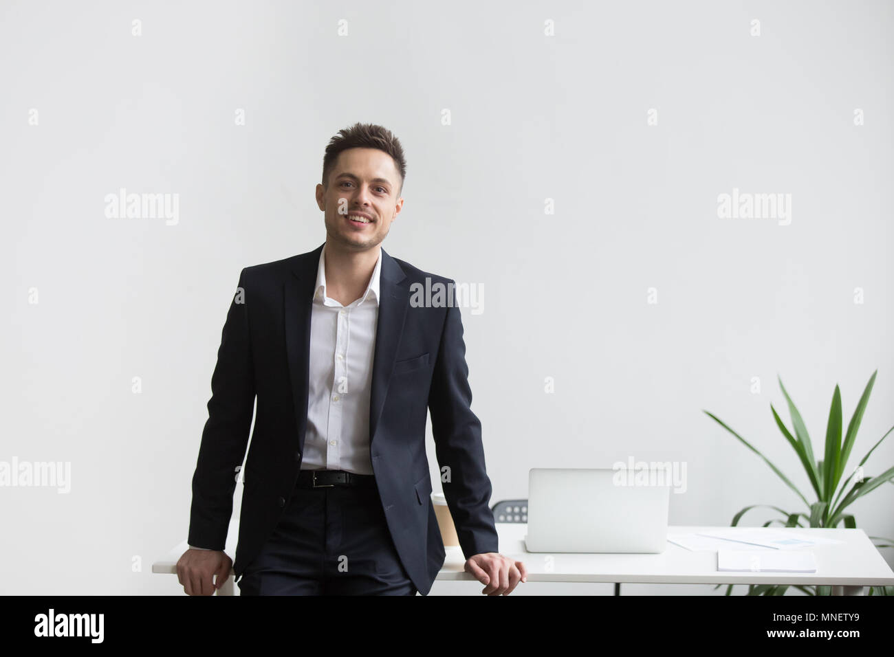 Lächelnd Company CEO in der Nähe von Büro Schreibtisch posing Stockfoto