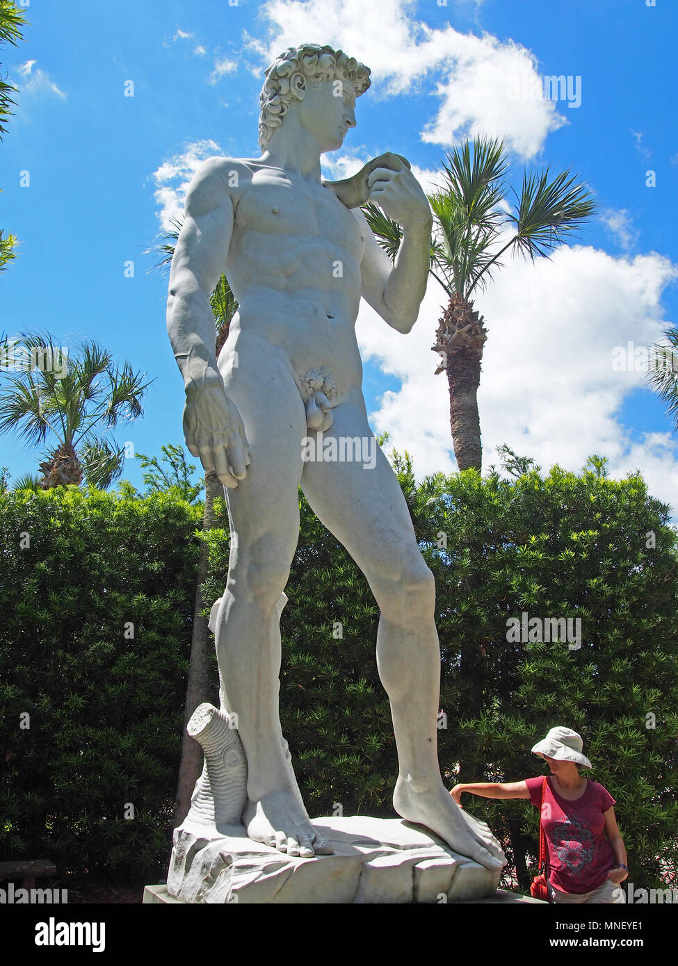 Frau berührt die Unterseite des riesigen David Reproduktion in St. Augustine, Florida, USA, 2018, © katharine Andriotis Stockfoto