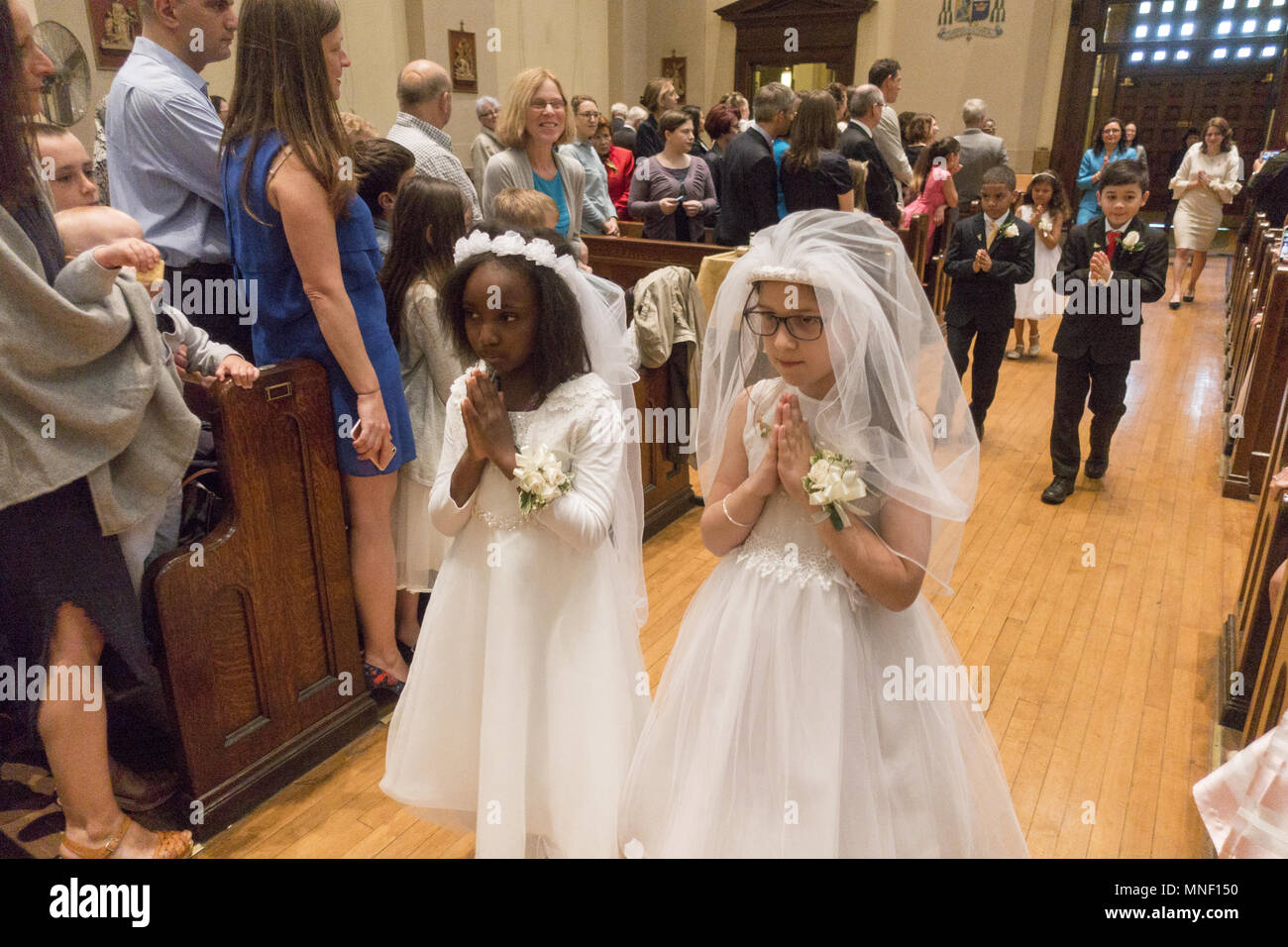 Die erste heilige Kommunion Zeremonie für Kinder an einer katholischen Kirche in Brooklyn, New York. Stockfoto