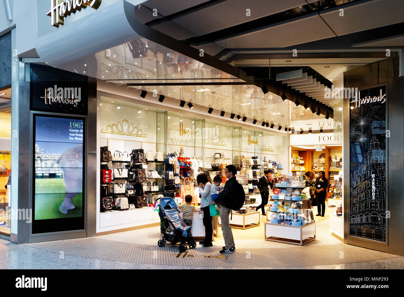 Eine asiatische Familie Shopping in Harrod's Duty free shop in London Heathrow Airport Terminal 2 Stockfoto