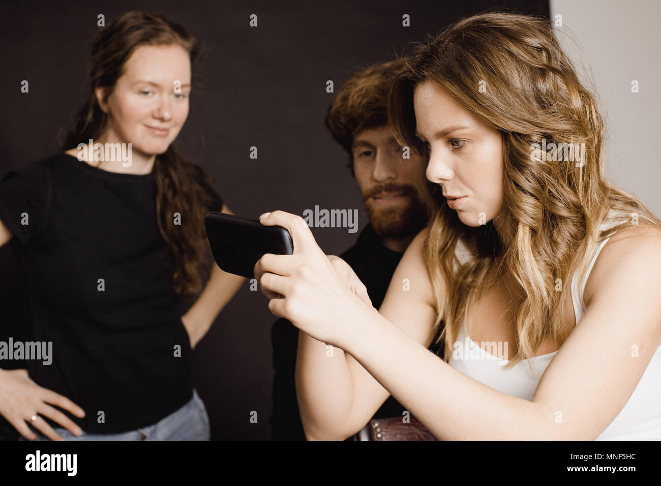 Menschen auf Bilder auf dem Smartphone suchen Stockfoto