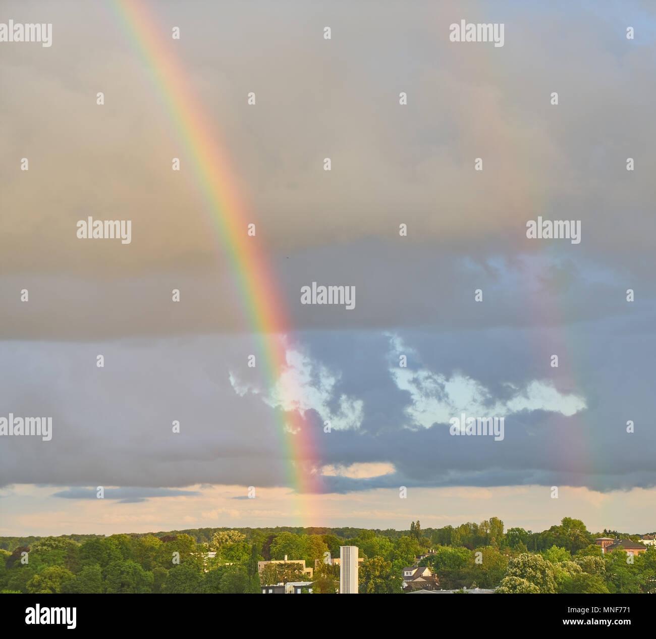 Starke Regenbogen nach dem schlechten Wetter in den Himmel über der Stadt Stockfoto