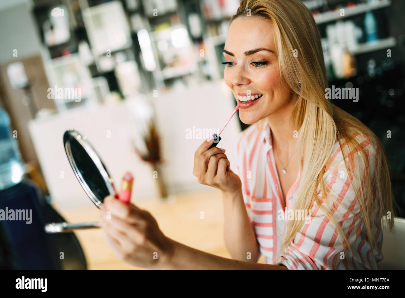 Junge schöne Frau Anwendung mit kleinen Spiegel machen Stockfoto