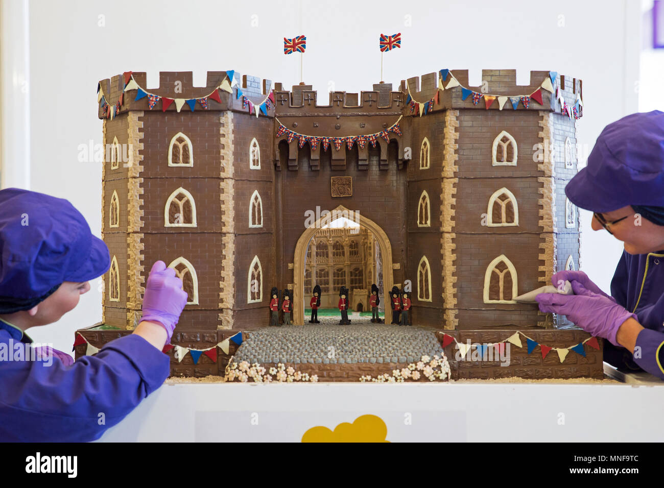 Chocolatiers Rohr den letzten Schliff an der Vorderseite des Windsor Castle an Cadbury World in Birmingham, die ganz aus Schokolade hergestellt und enthalten die Henry VIII Tor mit paspeliertem Bild von St George's Kapelle durch es sichtbar, vor der königlichen Hochzeit dieses Wochenende. Stockfoto