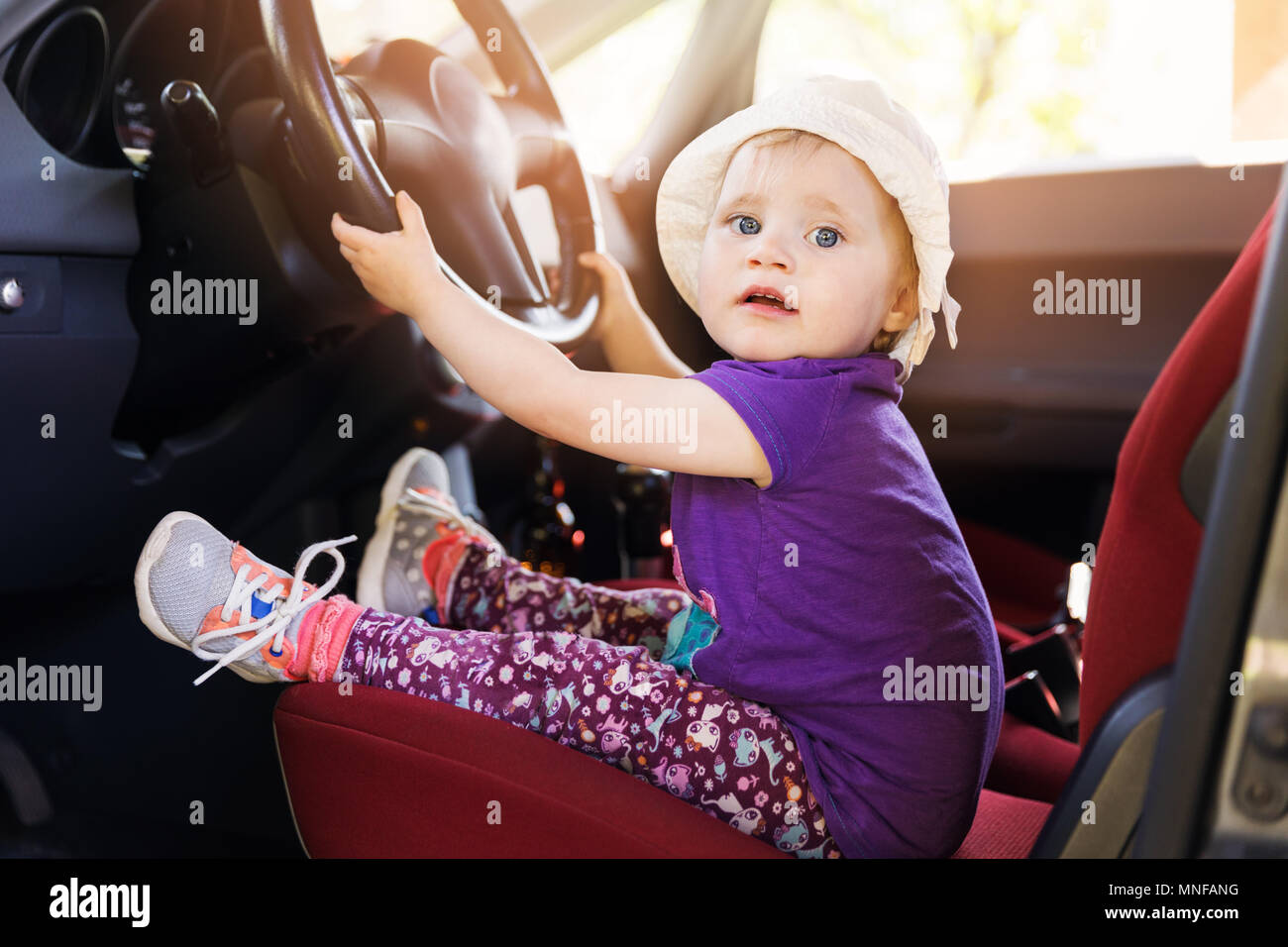 Süßes kleines Kind Lenkrad im Auto Stockfoto
