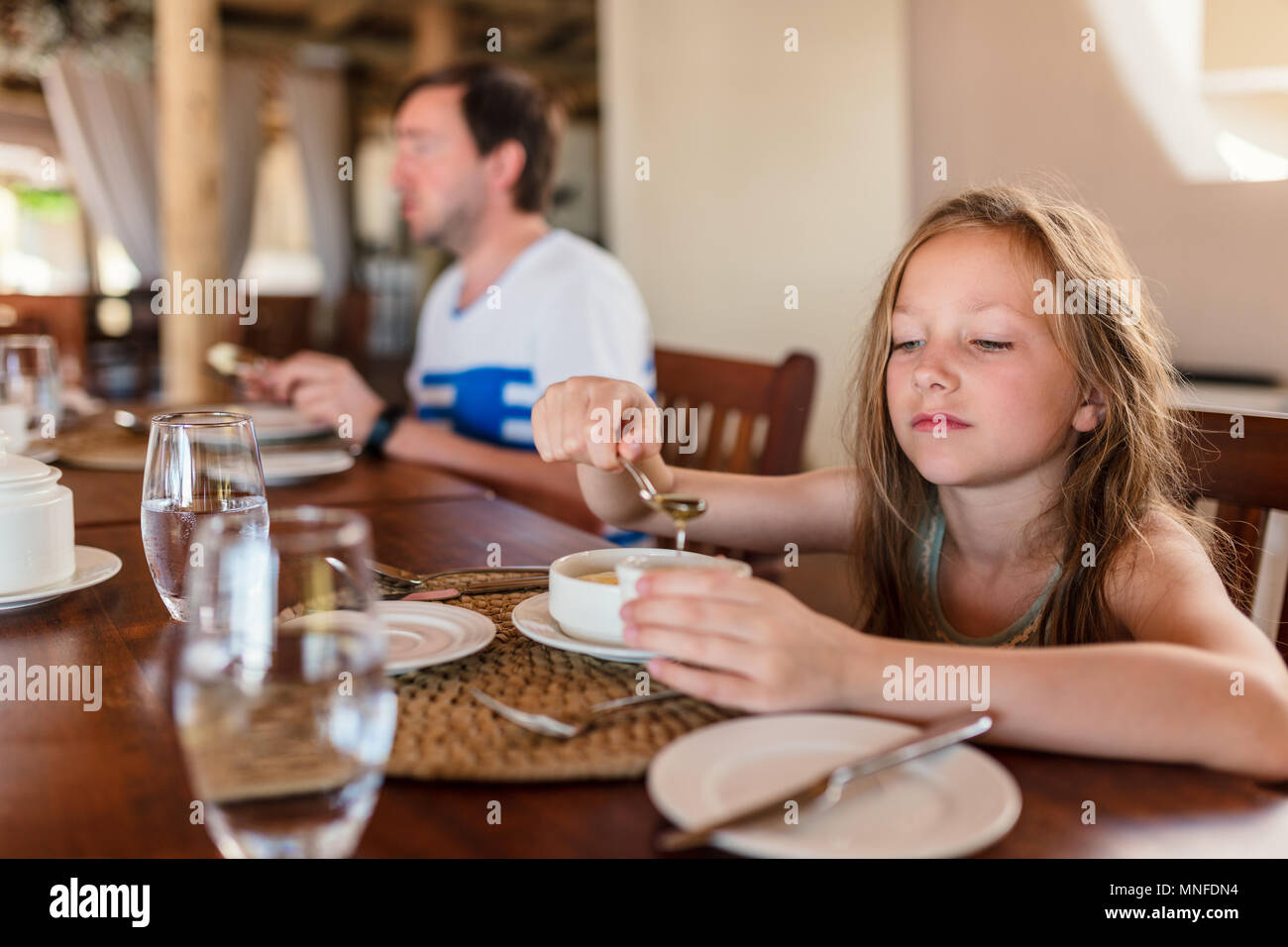 Adorable kleine Mädchen essen Frühstück im Haus oder im Restaurant Stockfoto