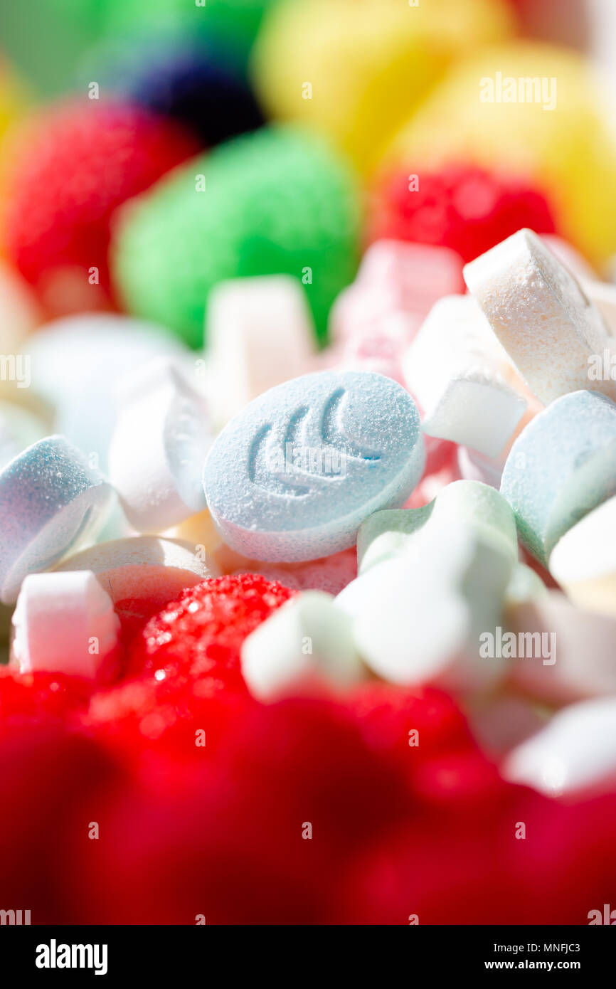 Süße Pillen und Tropfen in lebendigen Farben. Selektiver Fokus auf ovale Form Pille. Full Frame Hintergrund Stockfoto