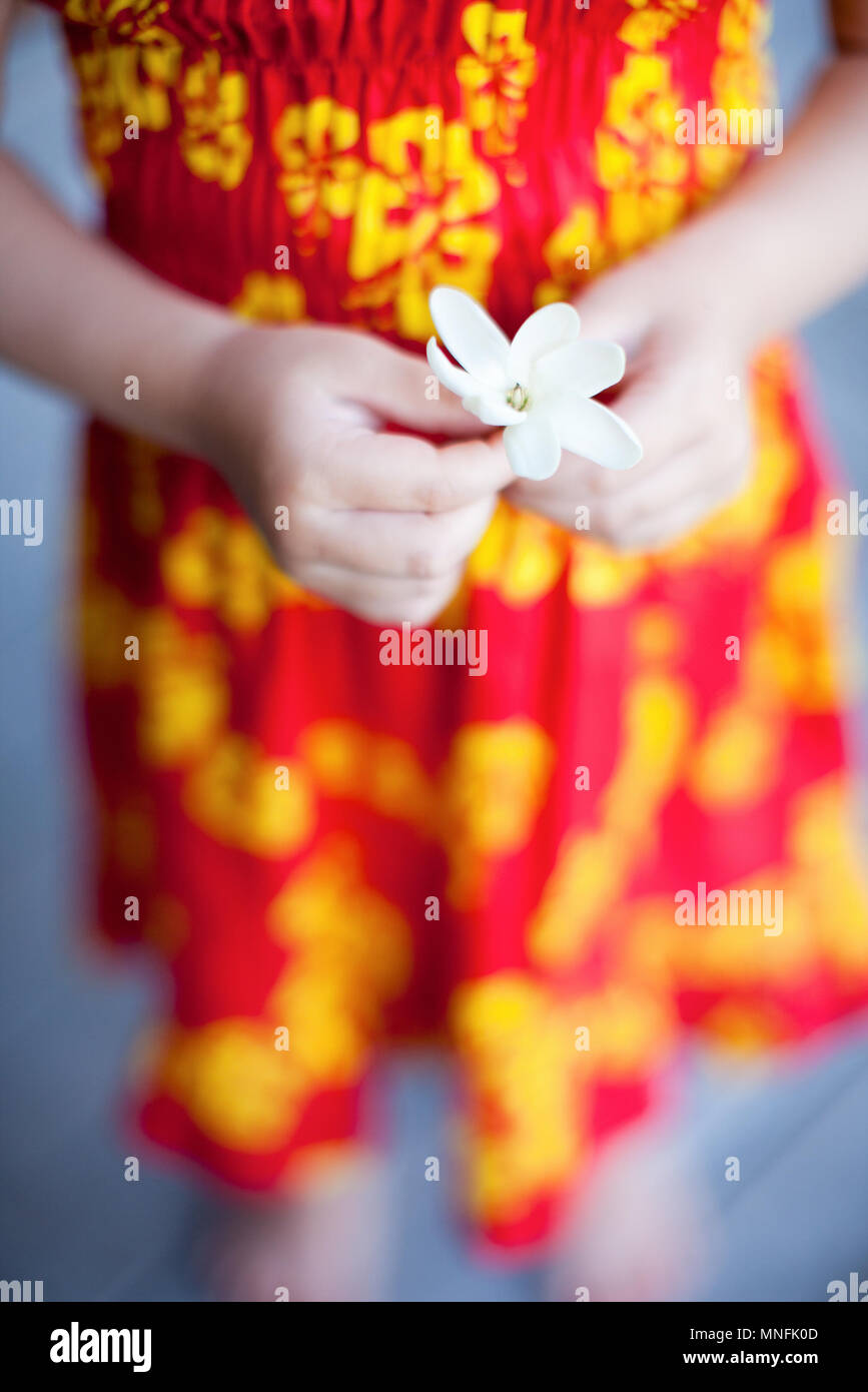 In der Nähe von Little girl Holding tahitian tiare Blume Stockfoto