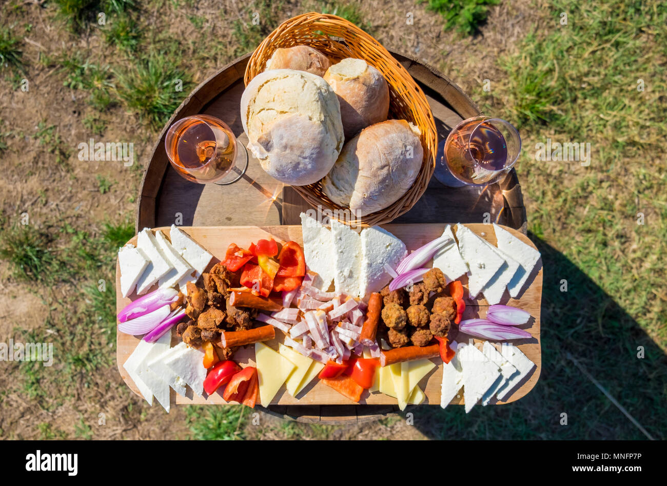 Essen mit traditionellen Osteuropa Essen: Zwiebeln, Brot, Käse, Würstchen, Frikadellen und Rotwein im Glas, in der Natur Stockfoto