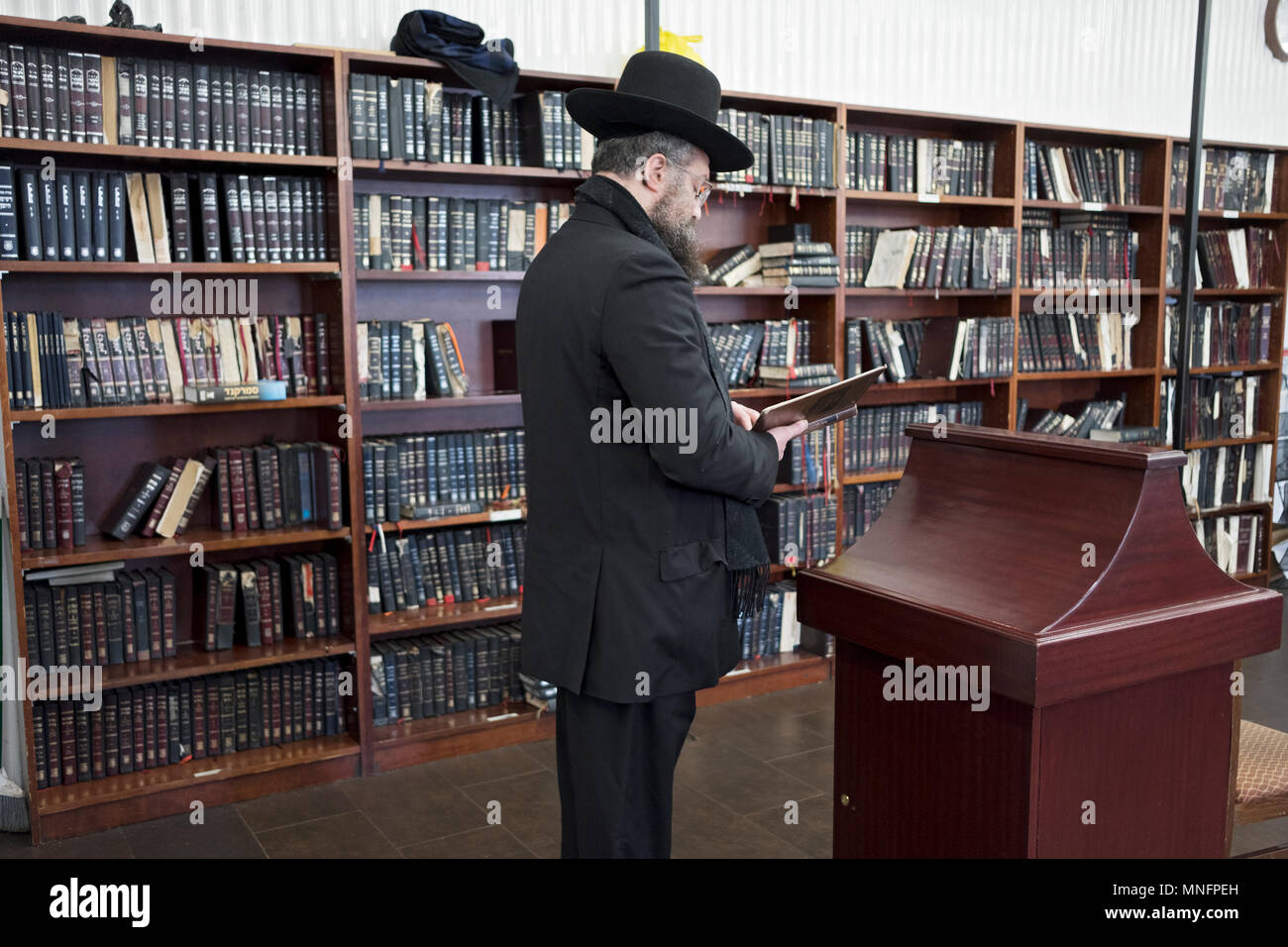 Einer orthodoxen jüdischen Mann in Schwarz gekleidet Gebet an die Synagoge in Cambria Heights, Queens, New York City. Stockfoto