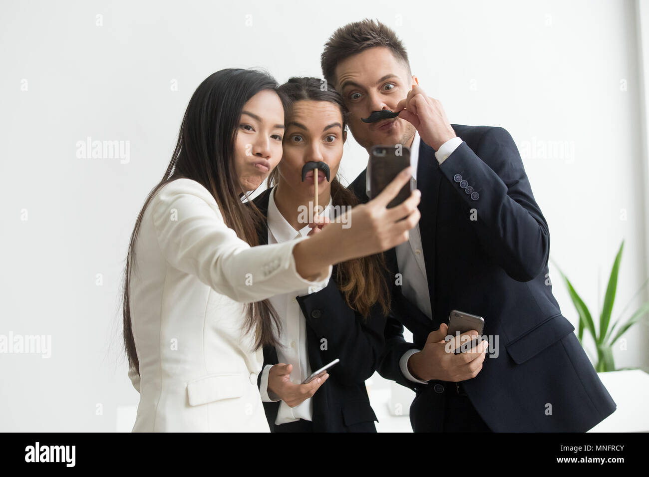 Mitarbeiter machen Bild mit Schnurrbart Zubehör Stockfoto