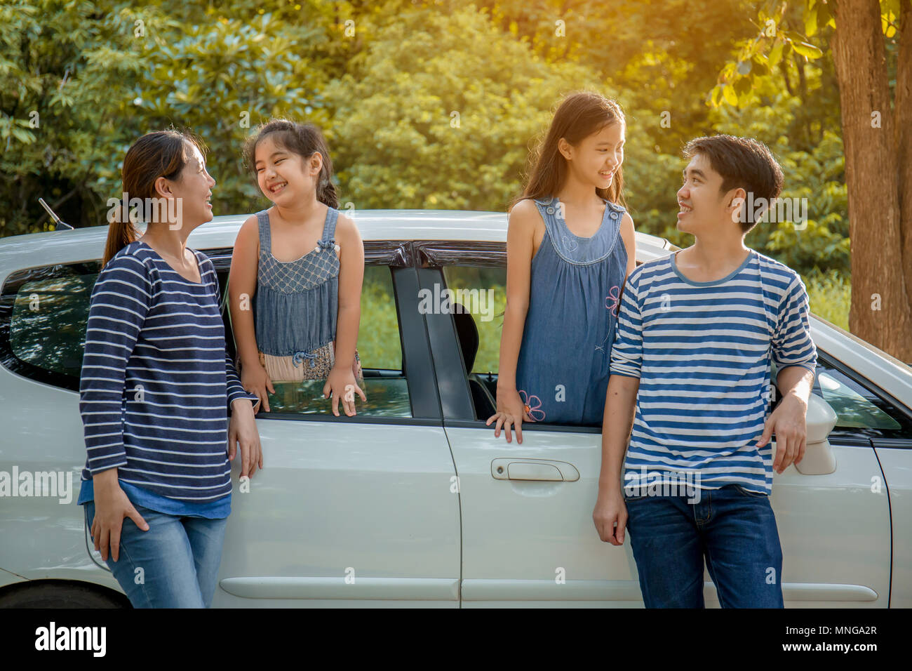 Gerne asiatische Familie auf Mini Van sind lächelnd und fahren für Reisen im Urlaub Stockfoto