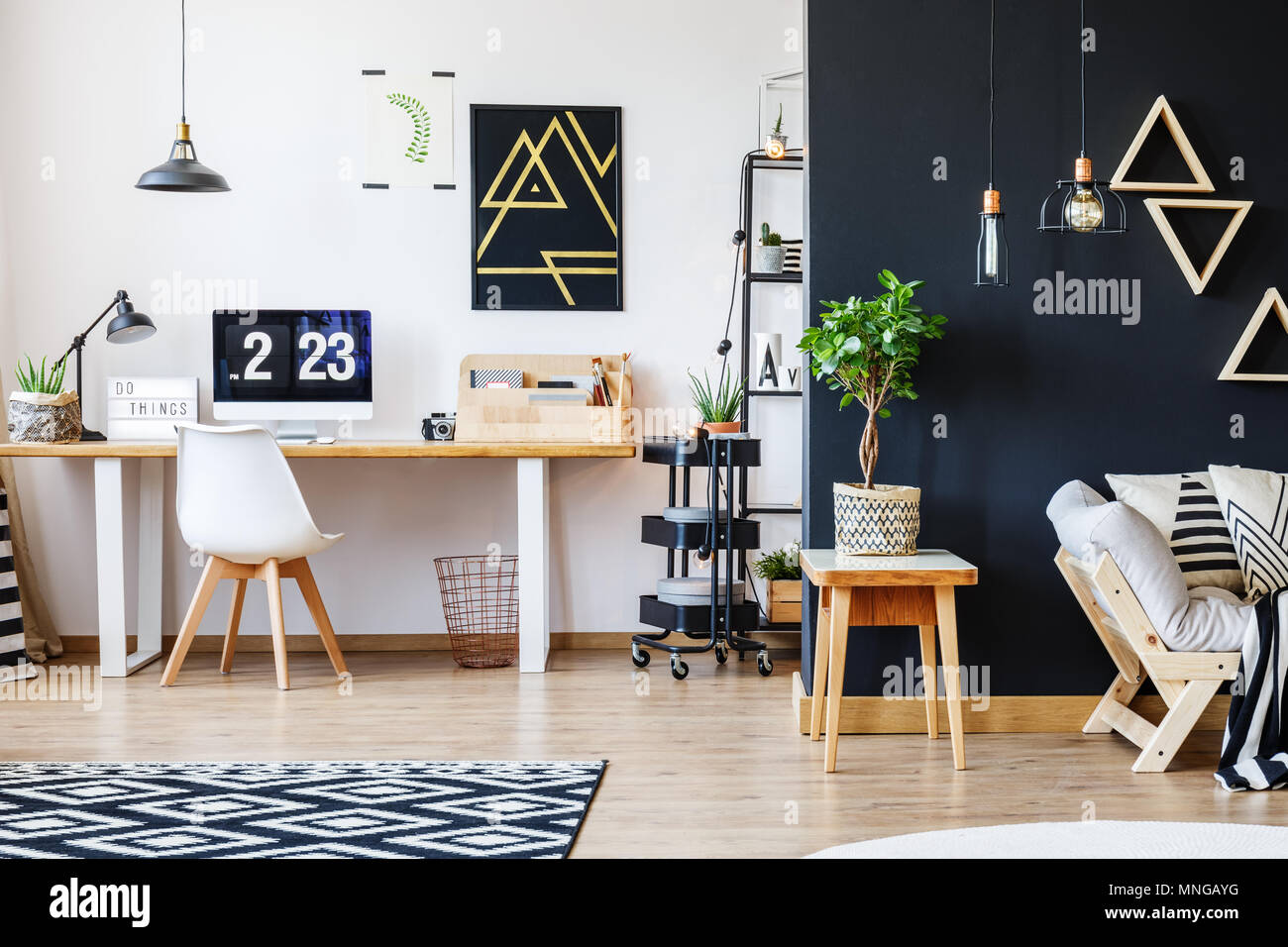 Nordic natürliche innere in der stilvollen Open Studio für einen Freiberufler mit Sofa, schwarze Wand und Büro mit Schreibtisch und schwarz Akzent Stockfoto