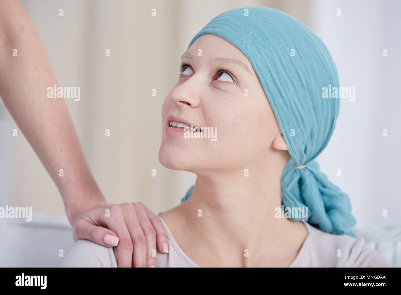 Junge Frau nach Chemotherapie Lächeln, das Tragen von Kopftuch Stockfoto