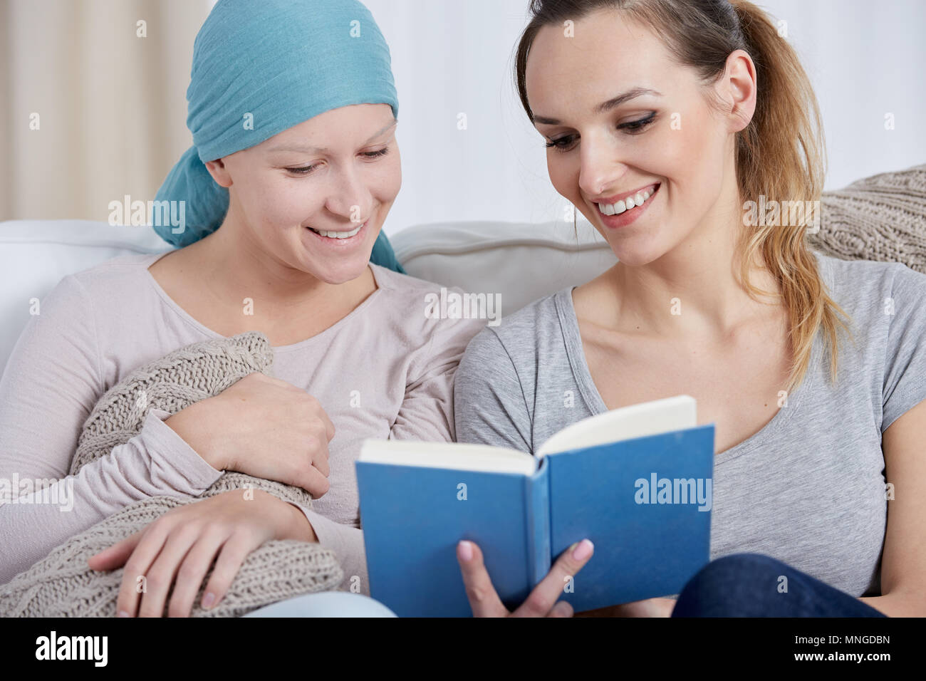 Happy Krebs Frau liest Buch mit ihrer Schwester Stockfoto