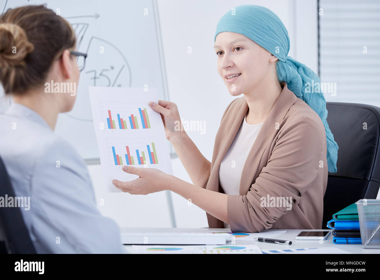 Frau nach Chemotherapie bei der Arbeit, im Gespräch mit Chef Stockfoto