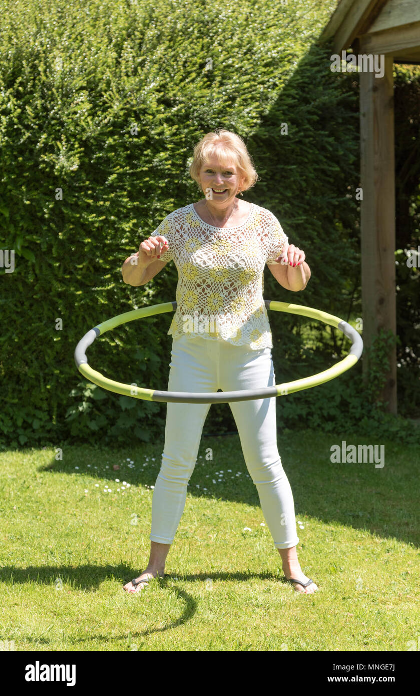 Frau mit einem Hula-Hoop-Reifen in einem Garten zu üben Stockfoto
