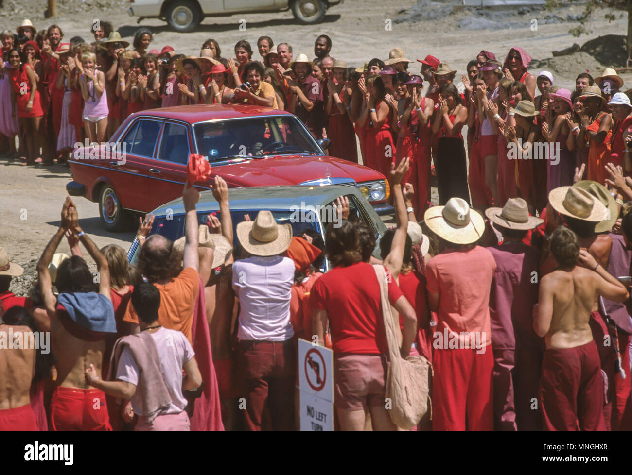 RAJNEESHPURAM, OREGON, USA - Rajneeshees, Anhänger von religiösen Sektenführer Bhagwan Shree Rajneesh, richten Sie ihren Führer fahren, indem in einem seiner Rolls Royce Autos zu sehen. 1984 Stockfoto