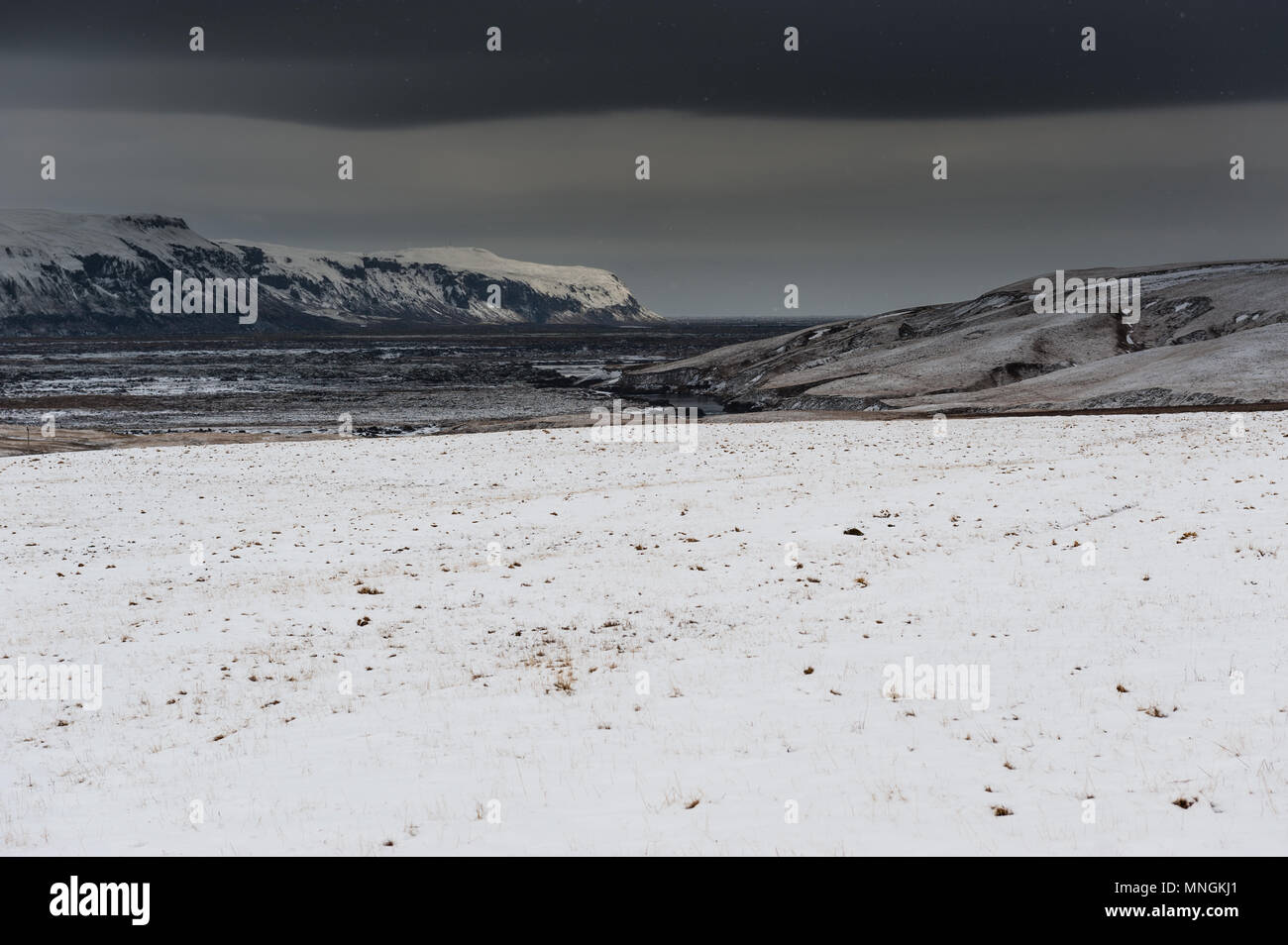 Melancholische Landschaft mit Wolke bedeckte Himmel und Schneefall in isländischer Land zurück, April 2018 Stockfoto