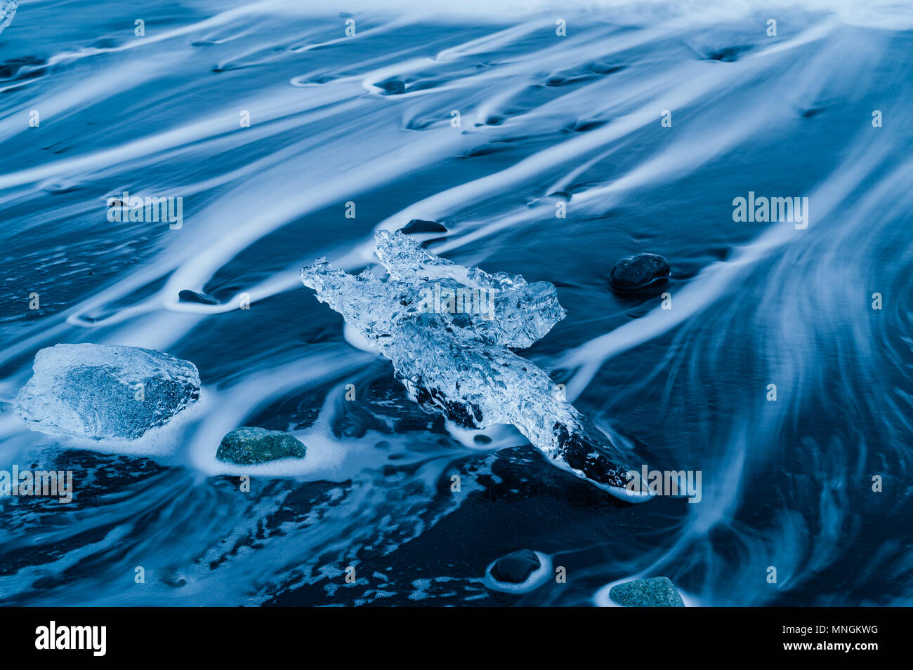 Eis Felsen durch die kommende Brandung des Atlantik an der schwarzen vulkanischen Sand gewaschen im Diamond Beach, Island april 2018 Stockfoto