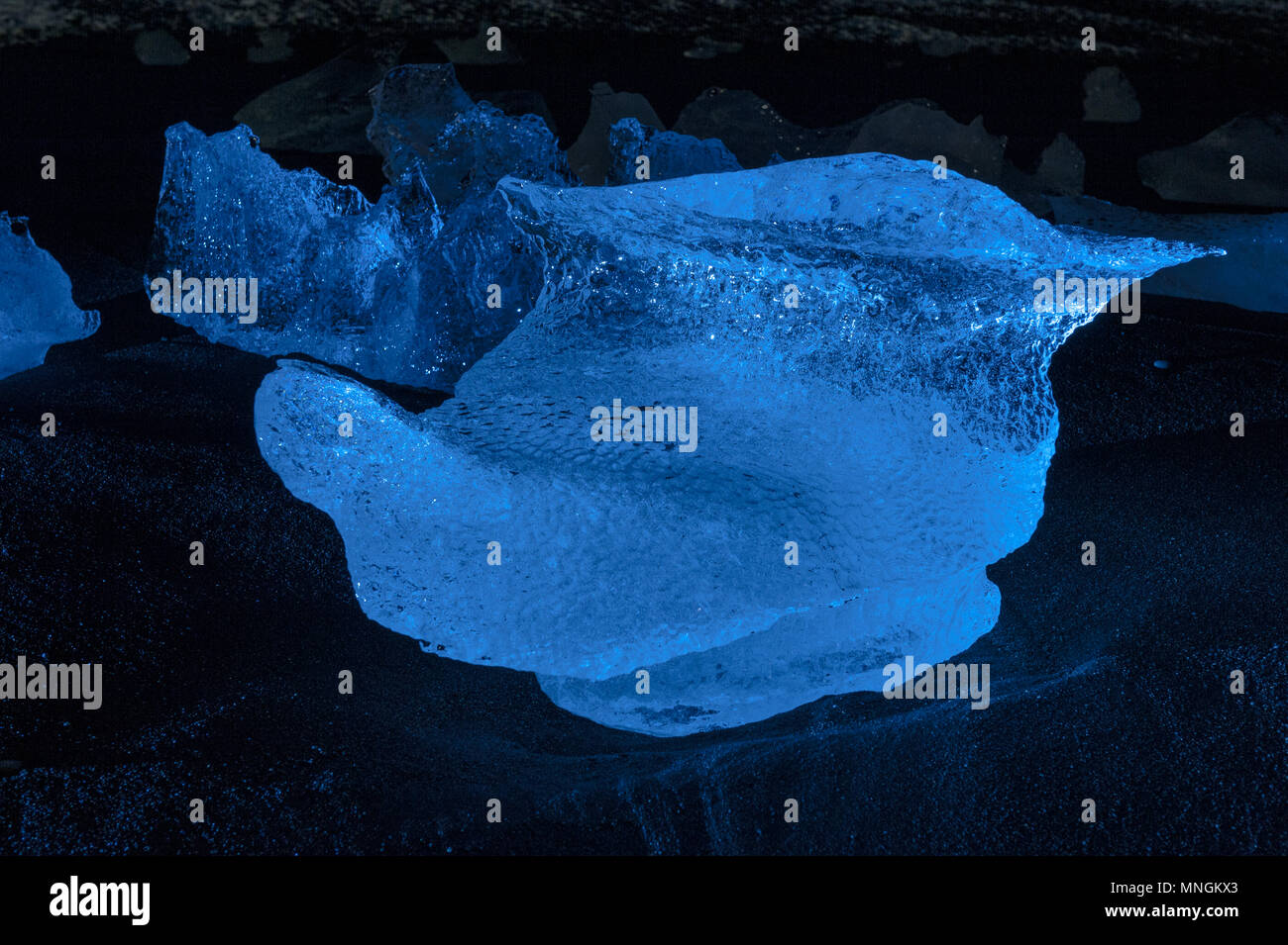 Beleuchtete Eis Felsen ta Nacht, bei den Schwarzen geschliffenen Diamanten Strand gespült, Island april 2018 Stockfoto