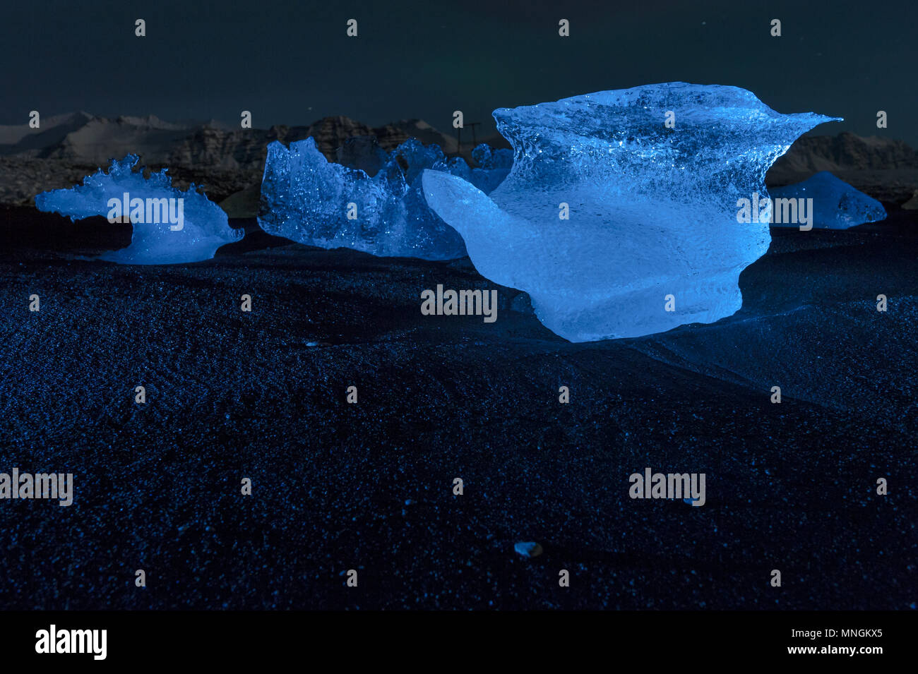 Beleuchtete Eis Felsen ta Nacht, bei den Schwarzen geschliffenen Diamanten Strand gespült, Island april 2018 Stockfoto