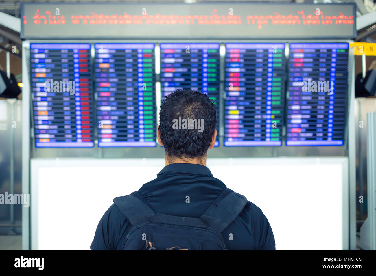 Mann an der Anzeigetafel im Flughafen suchen Stockfoto