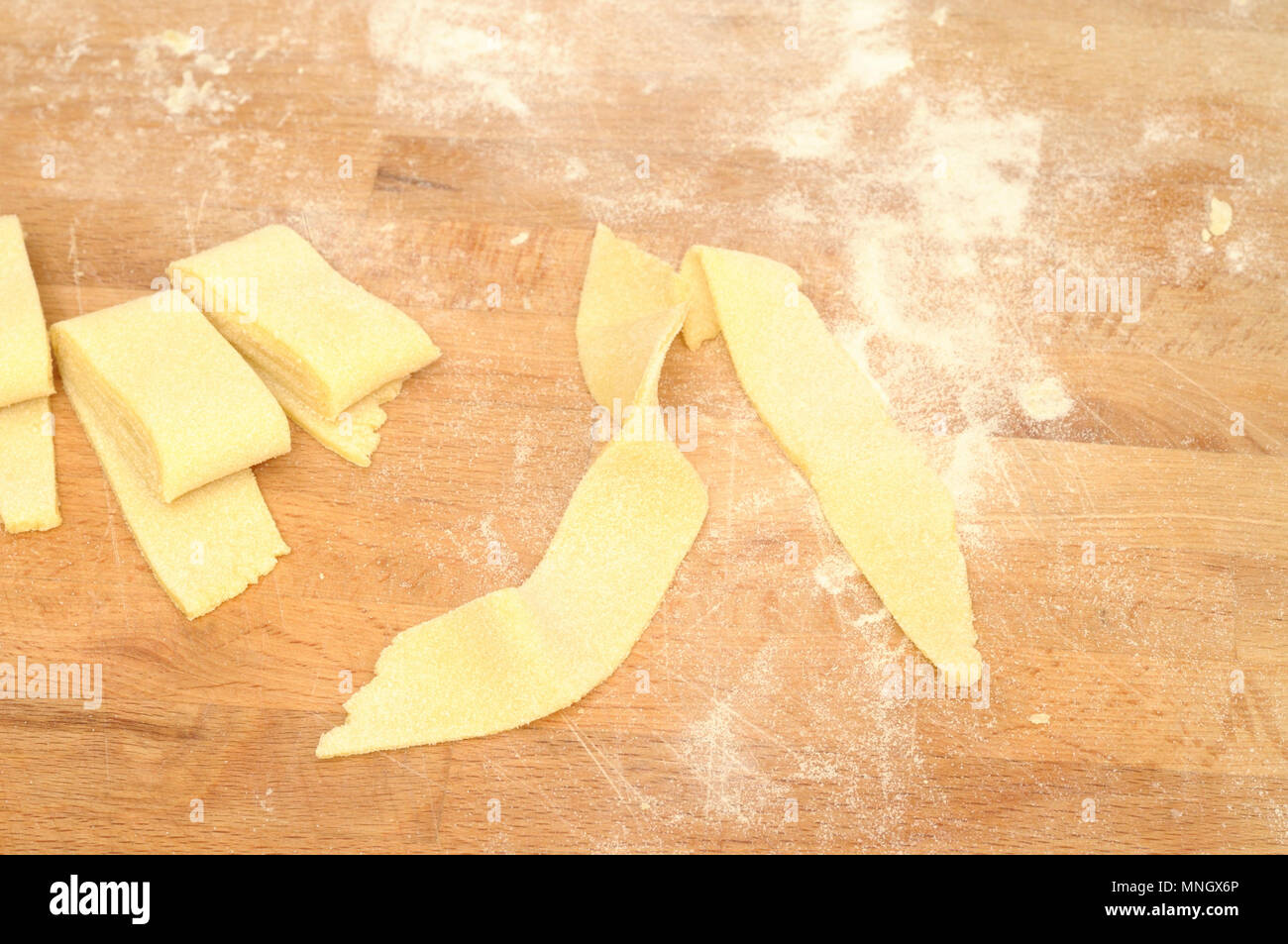 Italienische Pasta, Vorbereitung hausgemachte Frische fettuccine, auf Holzbrett, von oben. Typischerweise Pasta in Italien für den Urlaub vorbereitet Stockfoto