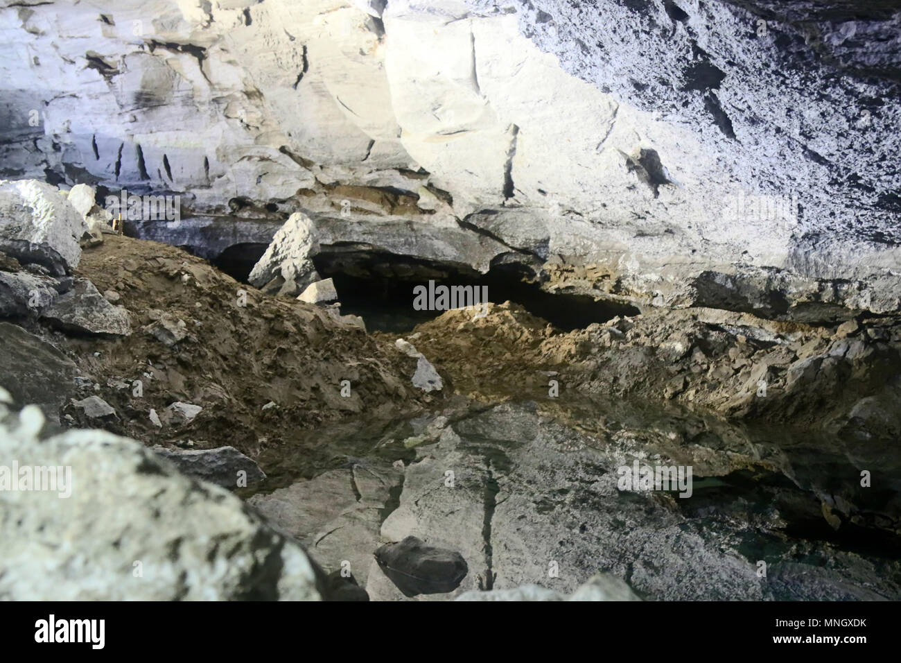 Hälfte - mit Rock und Lehm natürliche Höhle gefüllt. Nach dem Zusammenbruch der Tropfsteinhöhle, Steinschlag. Stockfoto