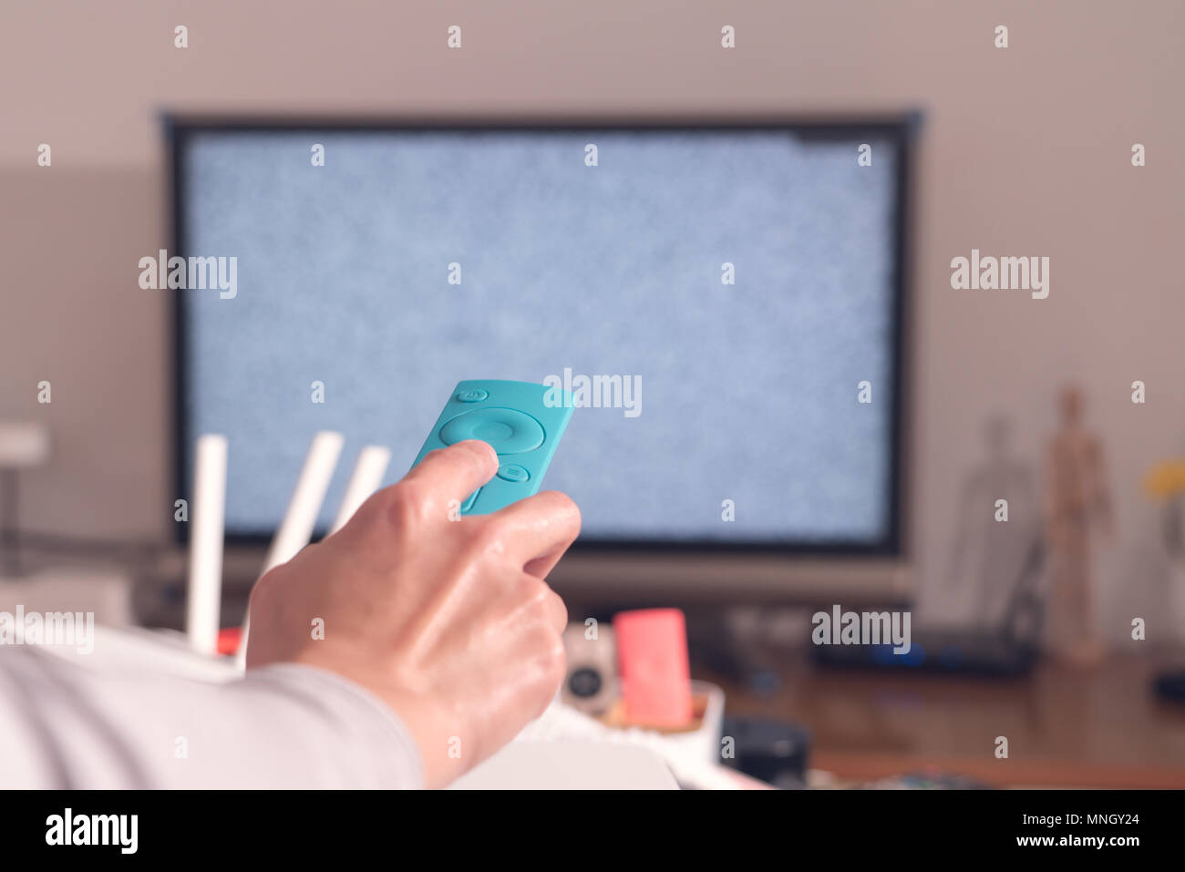 Frauen Hand halten Sie die Fernbedienung des TV Box im Wohnzimmer, der leere Bildschirm TV Stockfoto