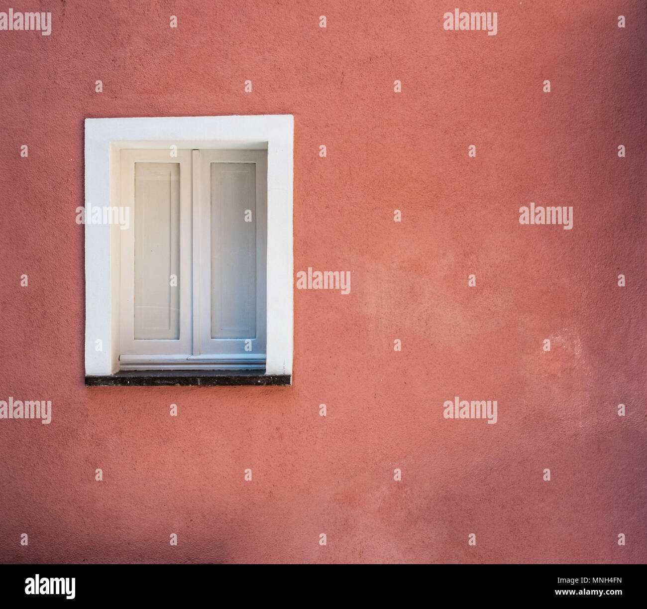 Weißes Fenster auf rosa Wand in Castelsardo - Sardinien Stockfoto