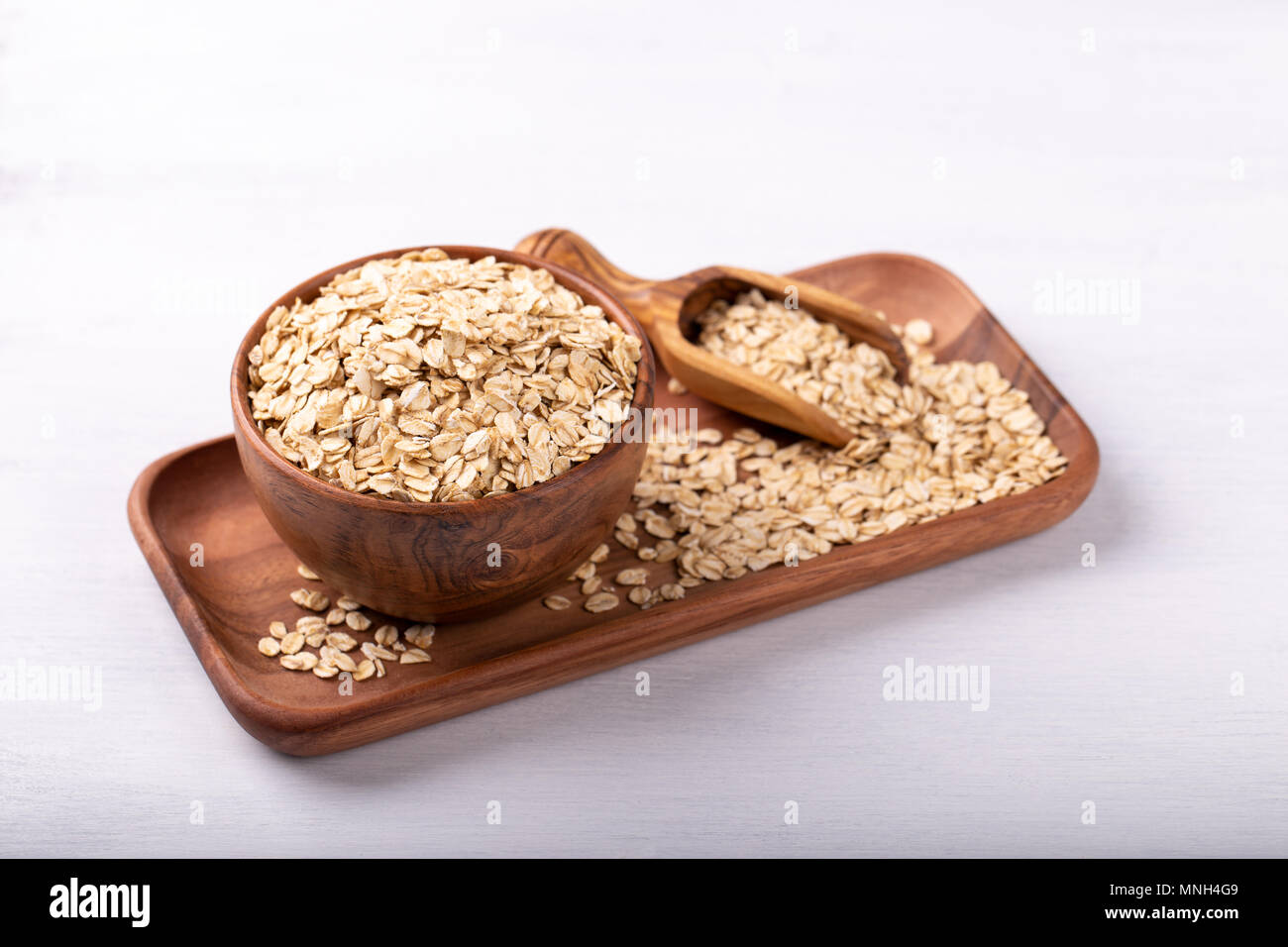 Altmodische Haferflocken in eine hölzerne Schüssel auf weiße Holztisch Stockfoto