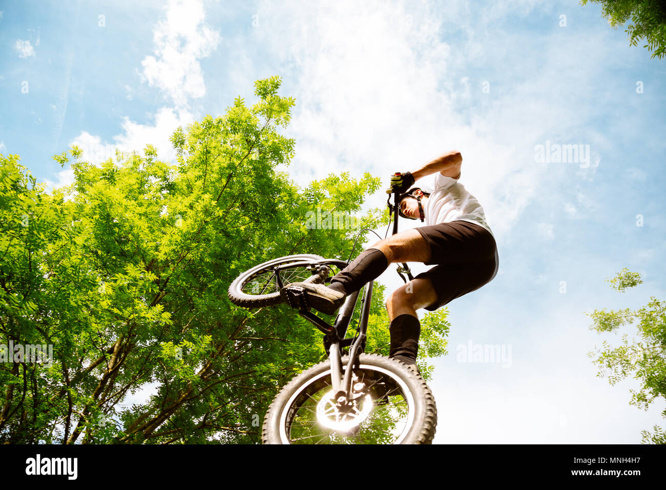 Junge Athleten springen mit einer Trial Fahrrad im Wald Stockfoto