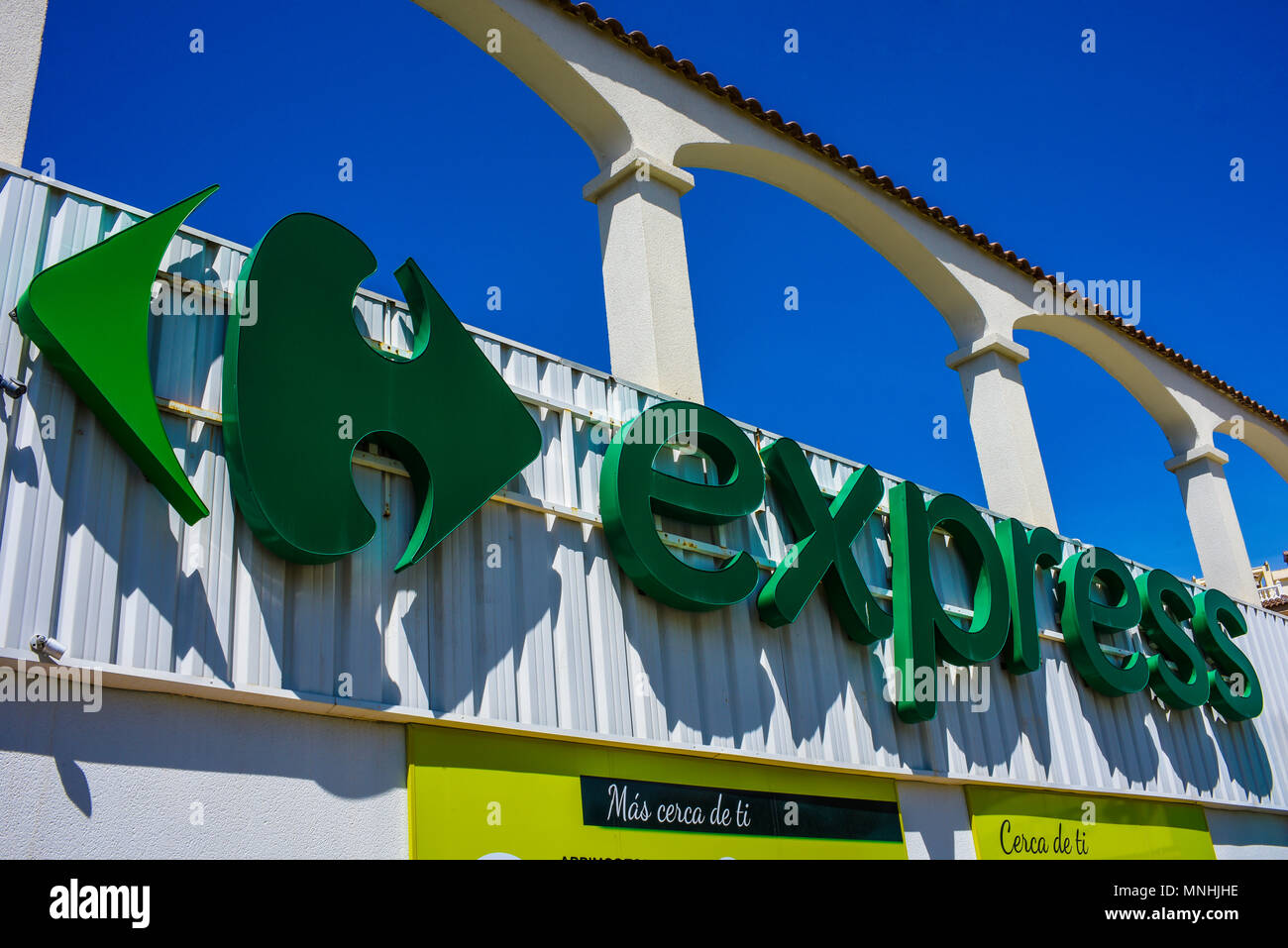 Express, die kleine lokale Marke von Carrefour. Carrefour Express Logo in Guardamar del Segura, Spanien. Blue Sky. Französische multinationale Stockfoto
