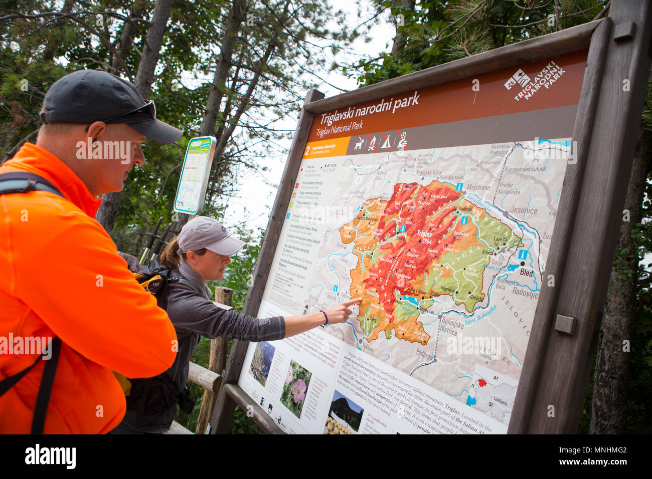 Ranger des Nationalparks Triglav zeigen auf Karte der Gegend, während die Touristen um Krn Mountain im Südwesten der Julischen Alpen im Nordwesten von Slowenien Stockfoto