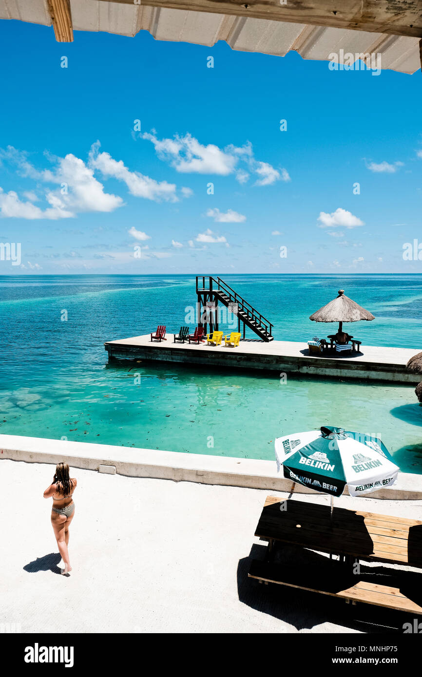 Frau gehen auf Sand in der Nähe der Beach Bar auf der Insel Caye Caulker, Belize, Belize Stockfoto