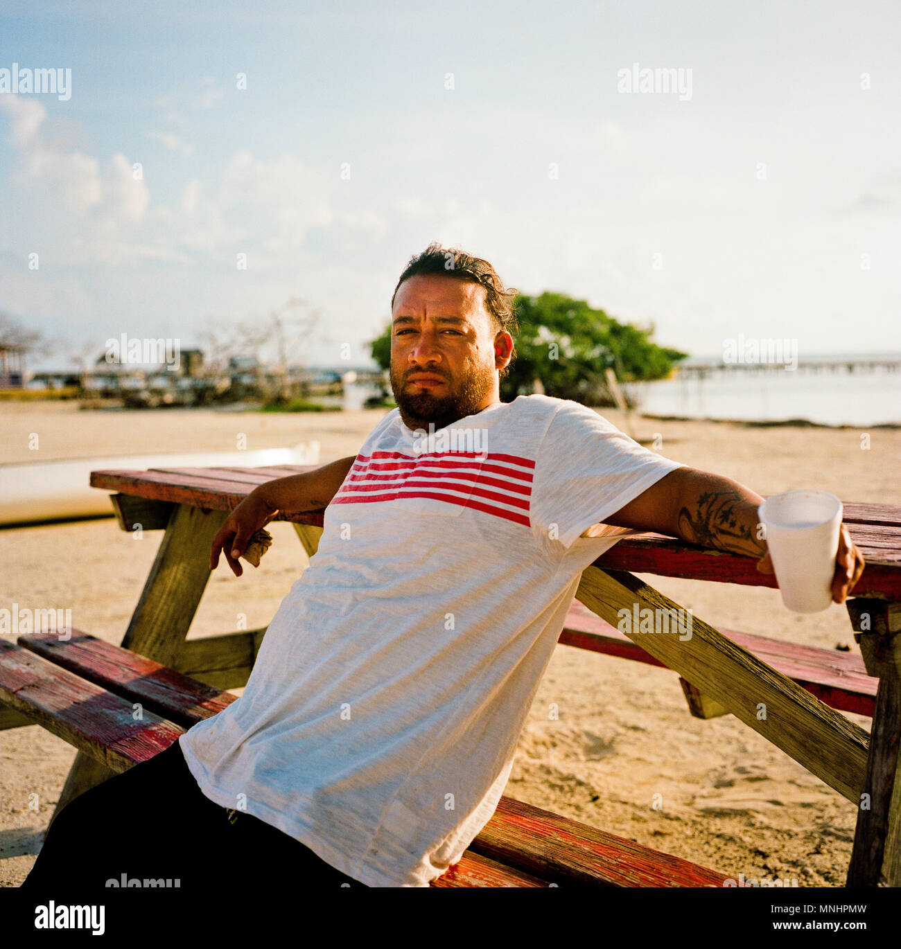 Porträt des Menschen auf der Holzbank am Strand ausruhen, Belize, Belize Stockfoto
