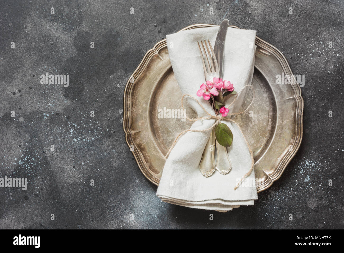Legen Sie die Einstellung mit rosa Blumen, Besteck auf vintage Hintergrund. Blick von oben. Stockfoto