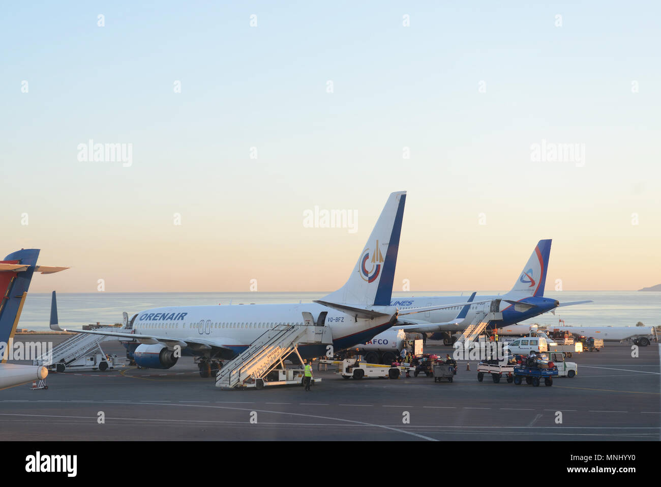 Tails einiger Flugzeuge am Flughafen beim Boarding operations. Sie sind Flugzeuge auf den Sonnenuntergang. Reisen und Transport Konzepte. Stockfoto