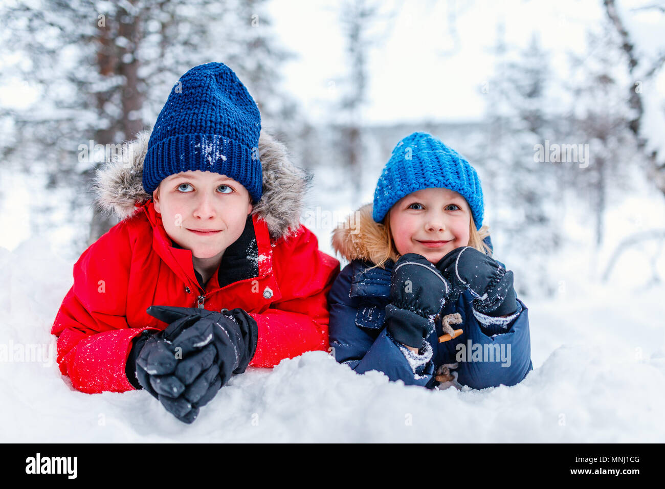 Cute adorable kleinen Mädchen und Jungen im Freien am Weihnachtstag in Spaß beim Spielen im Schnee. Stockfoto