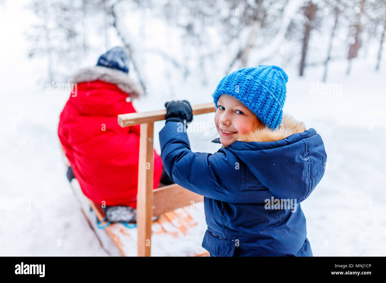 Cute adorable kleinen Mädchen und Jungen im Freien am Weihnachtstag in Spaß beim Spielen im Schnee. Stockfoto