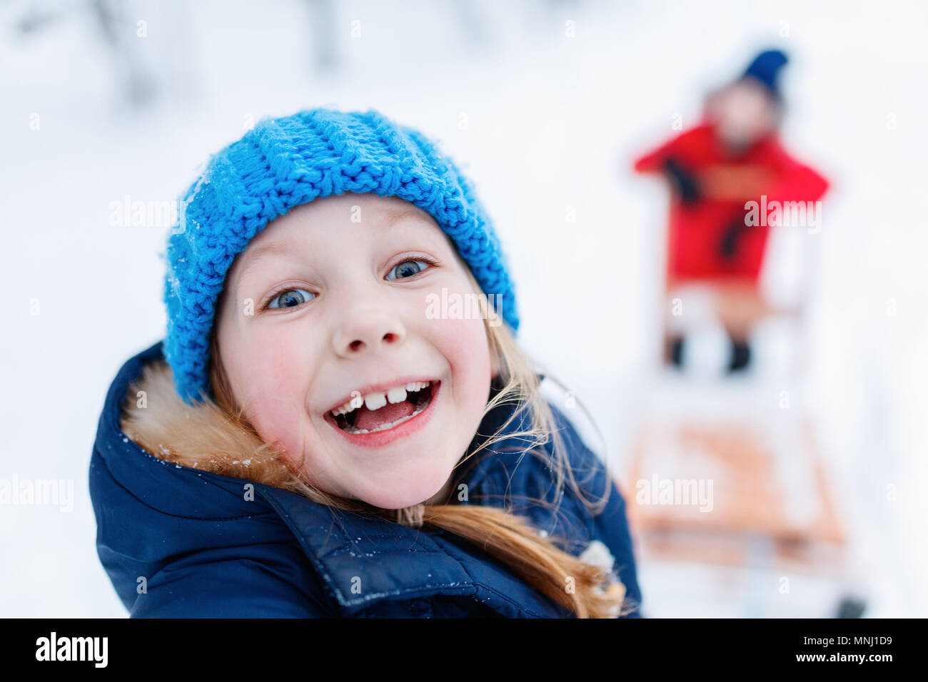 Cute adorable kleinen Mädchen und Jungen im Freien am Weihnachtstag Spaß Rodeln im Schnee Stockfoto