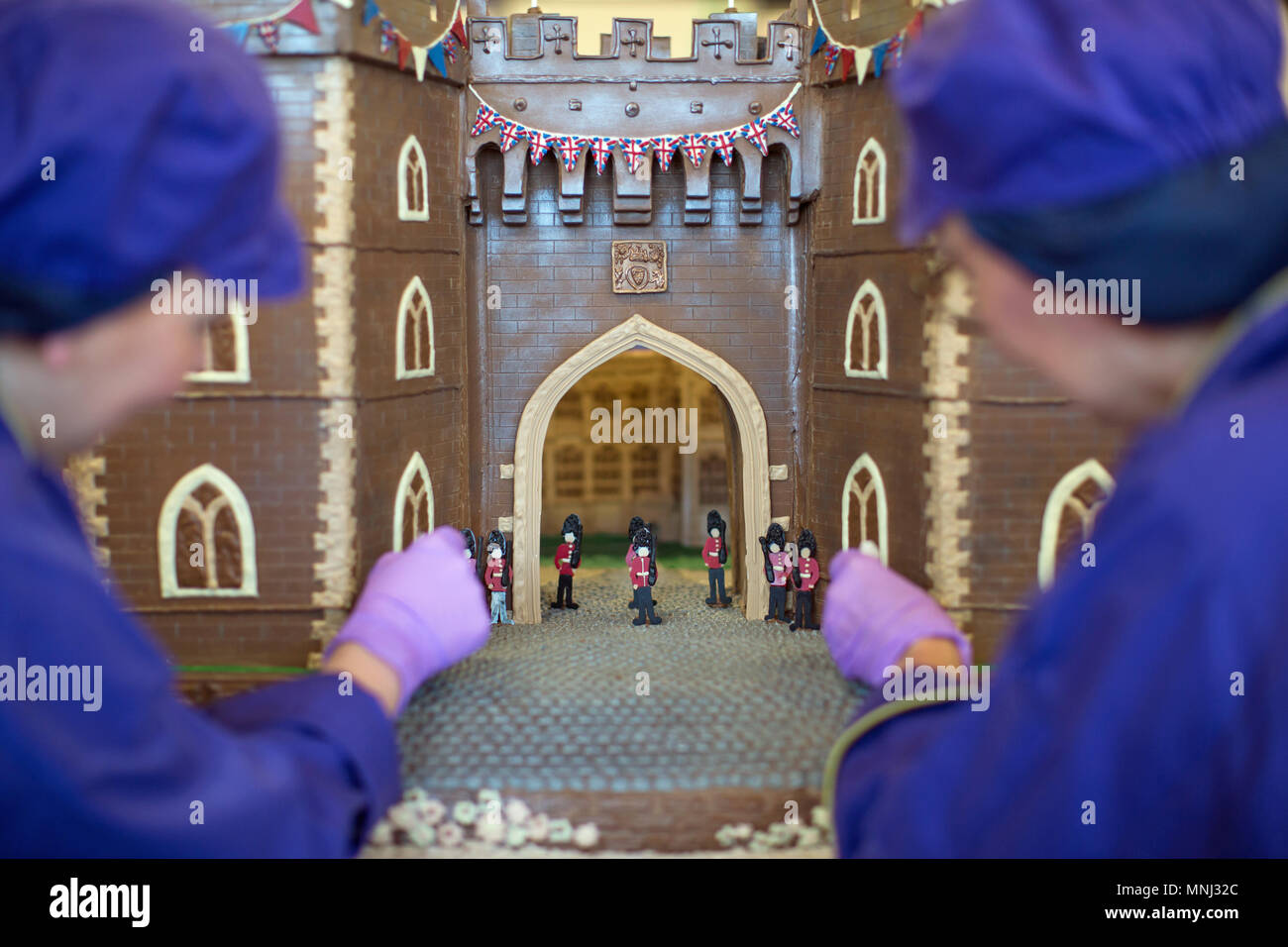Chocolatiers Rohr den letzten Schliff an der Vorderseite des Windsor Castle an Cadbury World in Birmingham, die ganz aus Schokolade hergestellt und enthalten die Henry VIII Tor mit paspeliertem Bild von St George's Kapelle durch es sichtbar, vor der königlichen Hochzeit dieses Wochenende. Stockfoto